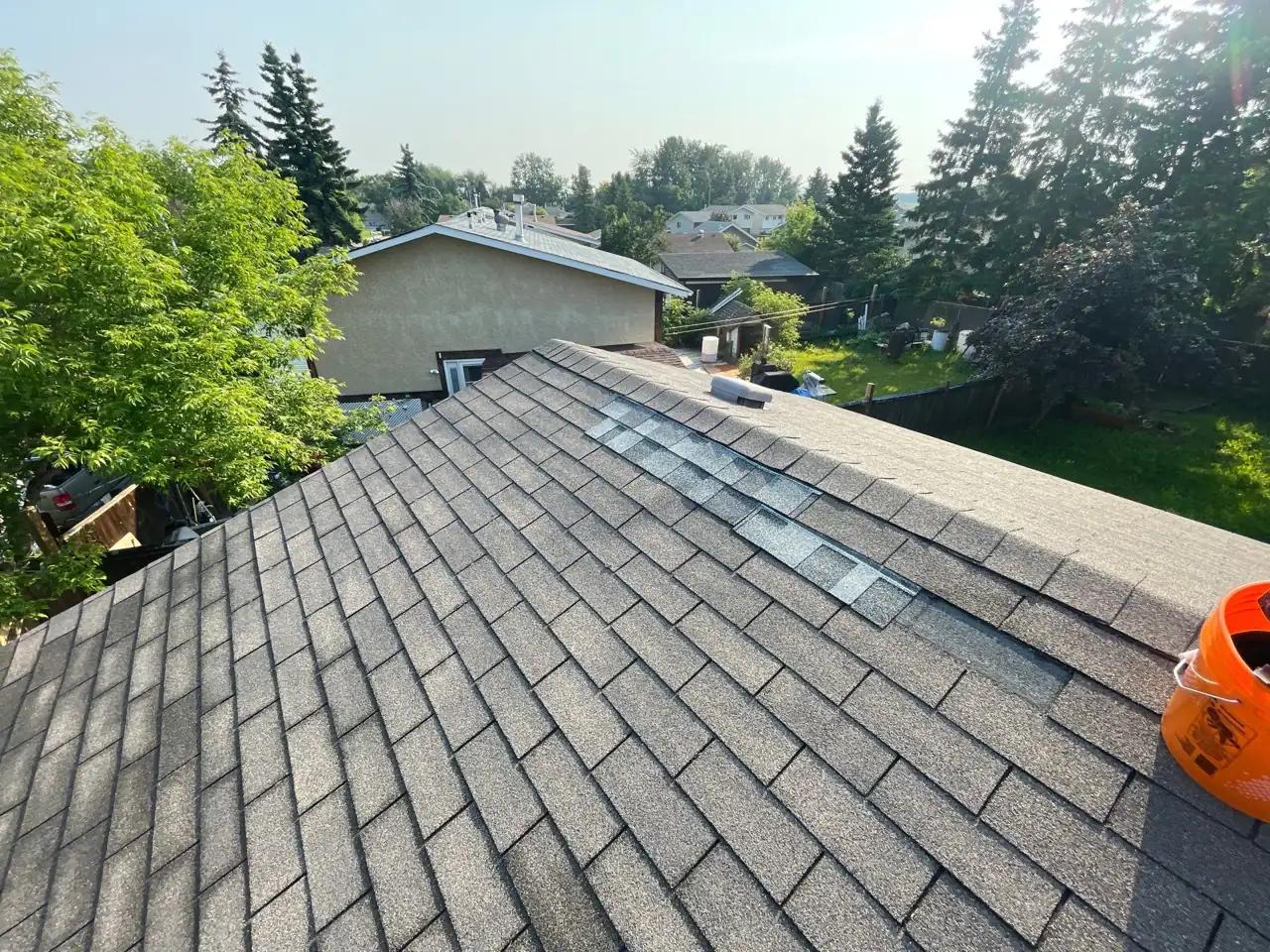 Roof ridge and slope on a Stony Plain home where wind-blown shingles were replaced